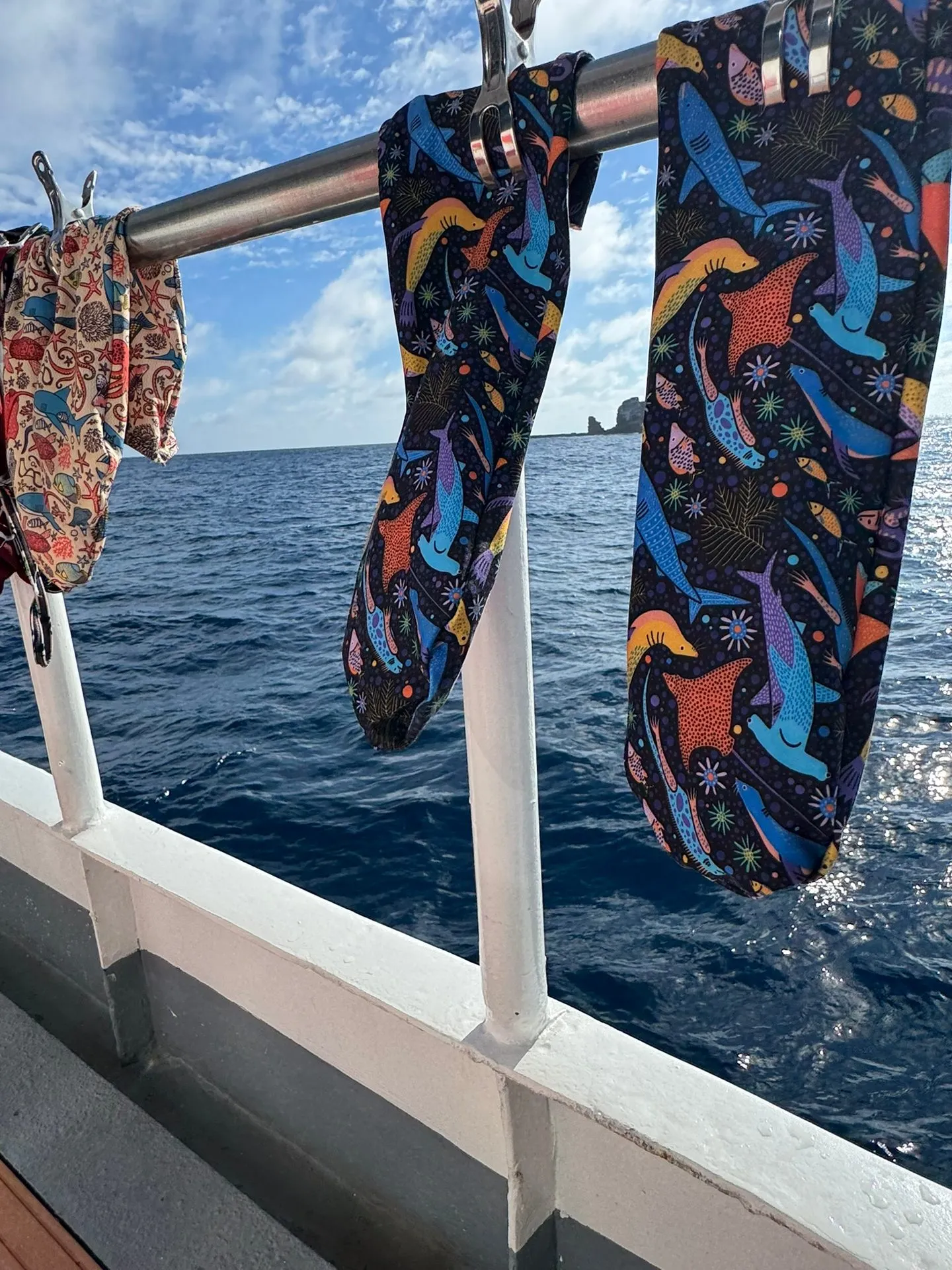 Two prototype socks with the Galápagos print hanging on the boat railing