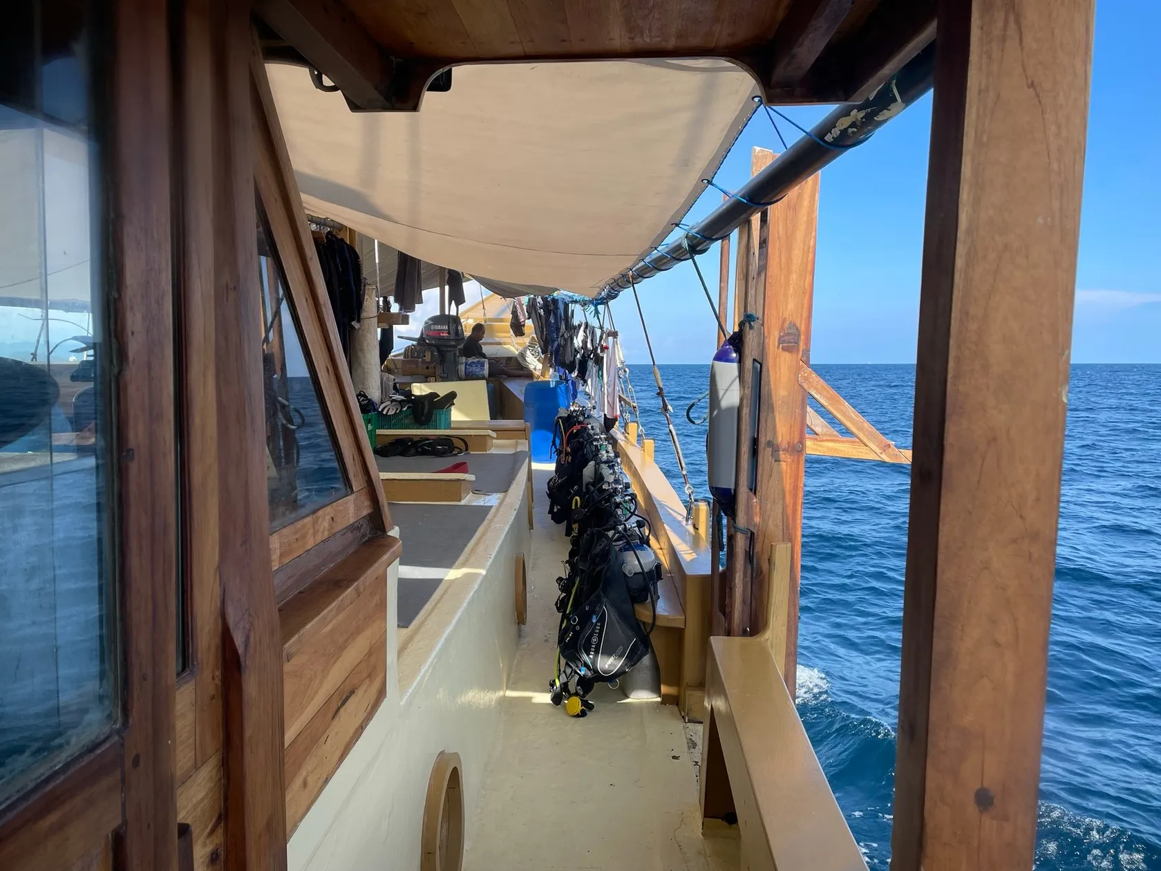 View along the dive deck of the Jaya, a wooden liveaboard, open sea beyond