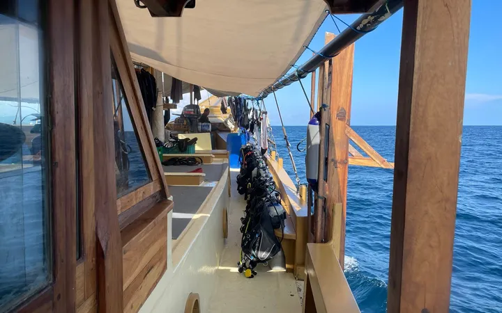 View along the dive deck of the Jaya, a wooden liveaboard, open sea beyond