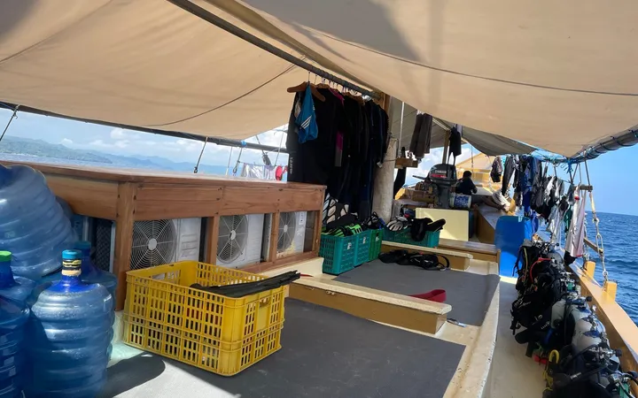 Dive deck of a liveaboard with gear stations under a canvas roof