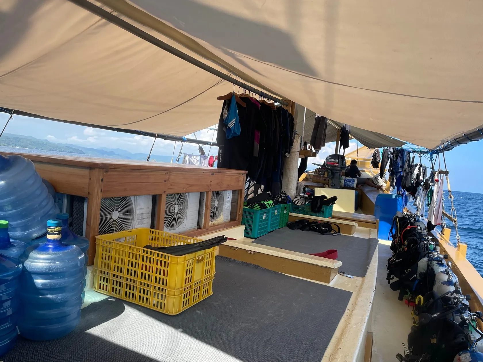 Dive deck of a liveaboard with gear stations under a canvas roof