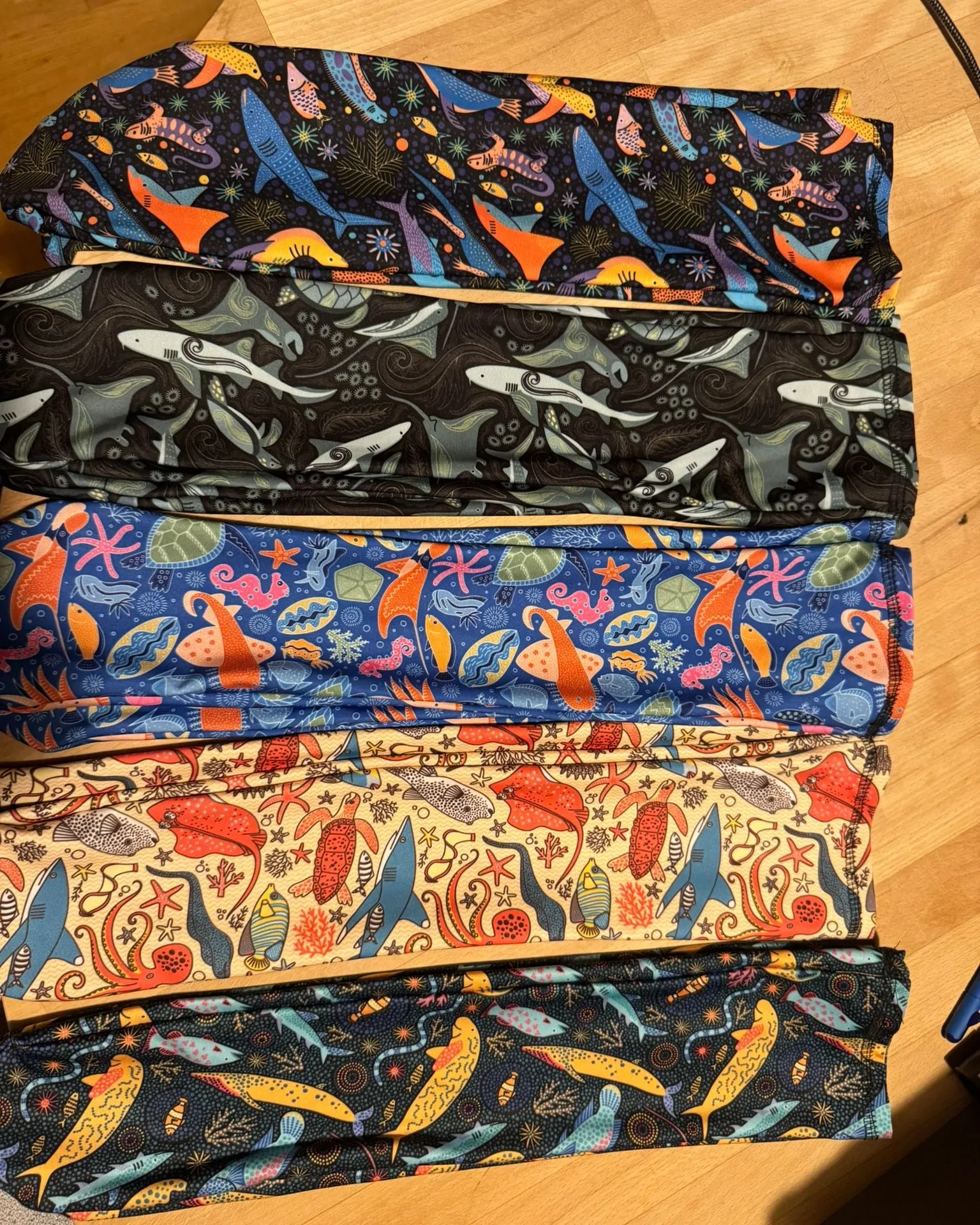 Five different marine prints on lycra fabric, folded and stacked