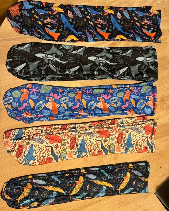 Three dive socks in different hand-drawn marine prints laid side by side